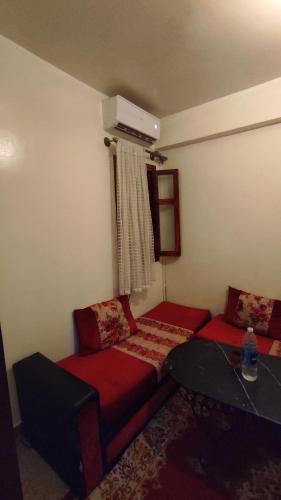 马拉喀什Résidence gharnata D5的一间设有两张红色床铺和一张桌子的房间