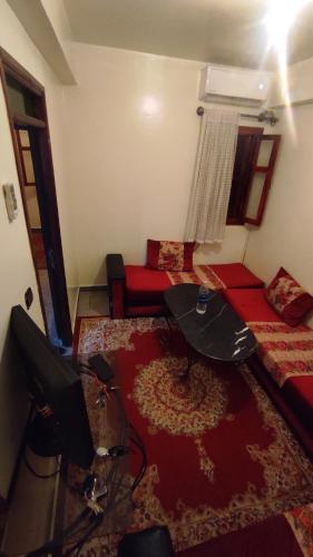 马拉喀什Résidence gharnata D5的客厅配有电视、沙发和桌子