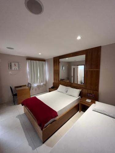 里约热内卢Verona Hotel的一间卧室配有两张床和一张书桌