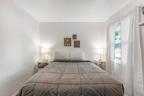 Ocean ParkCute as a Clam Cottage Room 2的白色卧室配有一张大床和两盏灯。