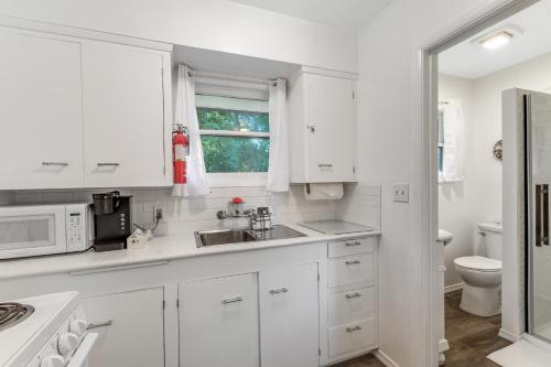Ocean ParkCute as a Clam Cottage Room 2的白色的厨房配有水槽和微波炉
