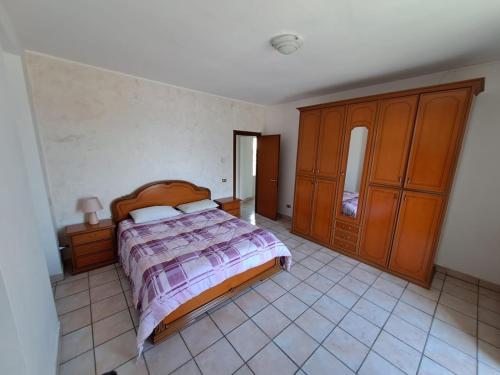 拉韦纳蓬泰特雷萨VILLA AIDA LAKE VIEW的卧室配有一张床和木制橱柜,铺有瓷砖地板。