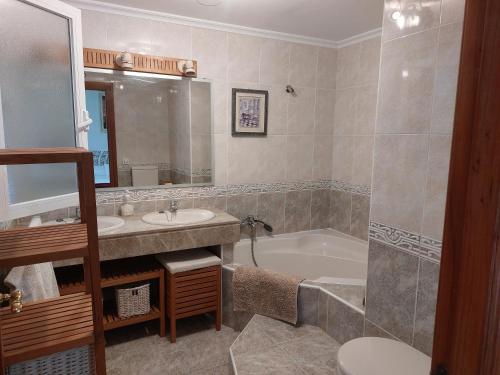 托尔梅斯河畔圣马尔塔Chalet urbano en Salamanca的一间带水槽、浴缸和卫生间的浴室