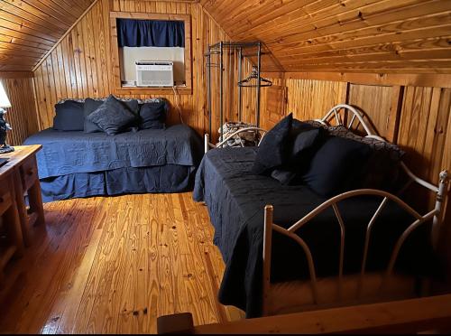 Lakewood HarborLake Whitney Log Cabin的小屋内一间卧室配有一张床和一张沙发