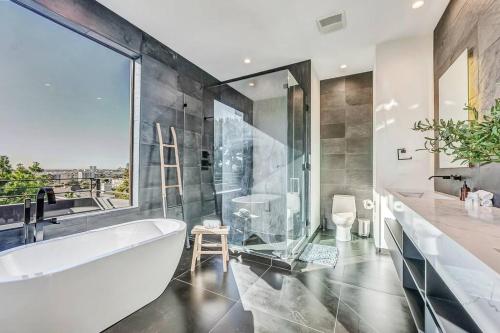 洛杉矶5BRM 6Bath Off Sunset in WeHo Villa的带浴缸的浴室和大窗户