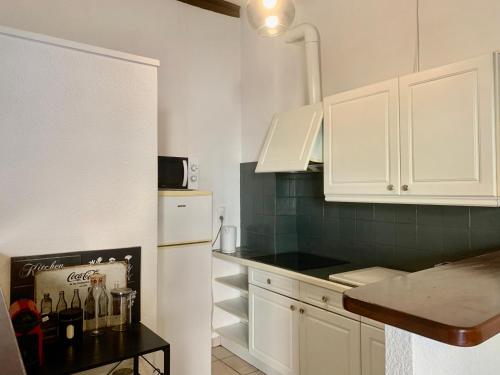 佩皮尼昂Le Cosy de la Vieille Intendance的厨房配有白色橱柜和白色冰箱。