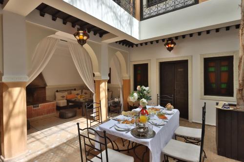 马拉喀什Riad 22 - L'Etoile d'Orient的一间配备有白色桌椅的用餐室