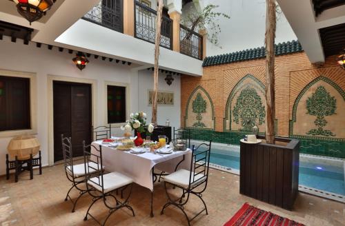 马拉喀什Riad 22 - L'Etoile d'Orient的一间带桌子和游泳池的用餐室