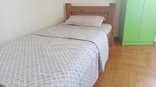 波德戈里察Central Home的卧室配有带白色棉被的床