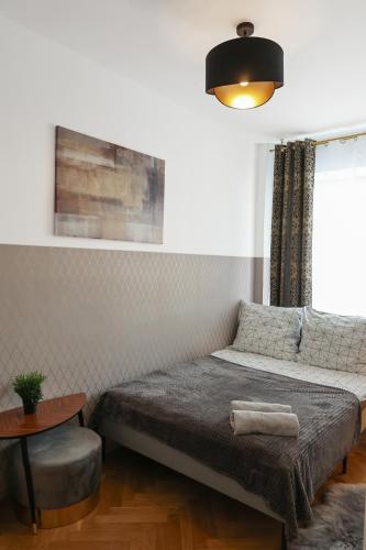 华沙ClickTheFlat Three Crosses Square Apart Rooms的一间卧室配有一张床、一张桌子和一个窗户。