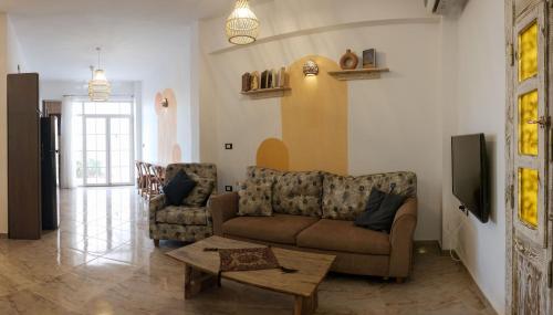 达哈布Tranquilo Boutique Hostel - Dahab的客厅配有沙发和桌子