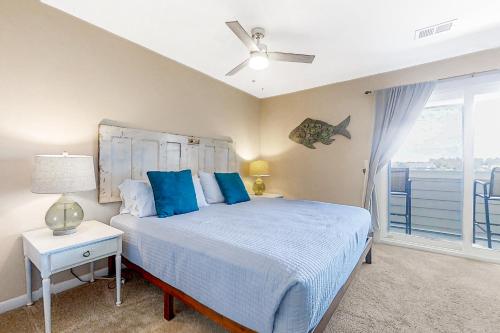 富丽海滩The Southern Harmony的一间卧室配有一张带蓝色枕头的床和一扇窗户。