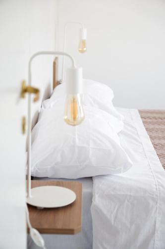 圣达菲HomeRental SF (departamentos céntricos en alquiler temporario)的一张带白色床单的床和一张带台灯的桌子