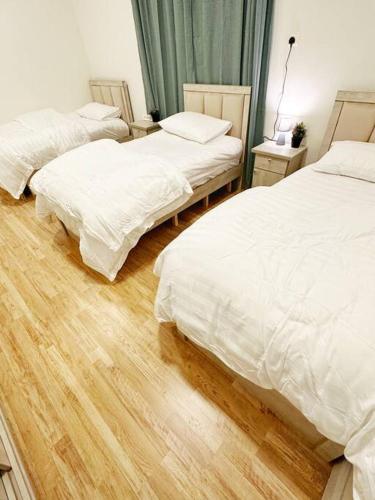 利雅德2 Bedroom Apartment 2BB的一间卧室设有两张床,铺有木地板