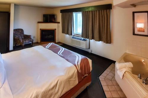 AtchisonQuality Inn Atchison的酒店客房配有一张床和浴缸。