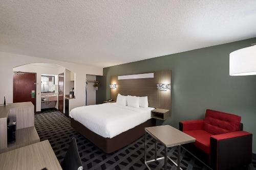 欧文DFW机场南品质套房酒店的酒店客房,配有一张床和一张红色椅子