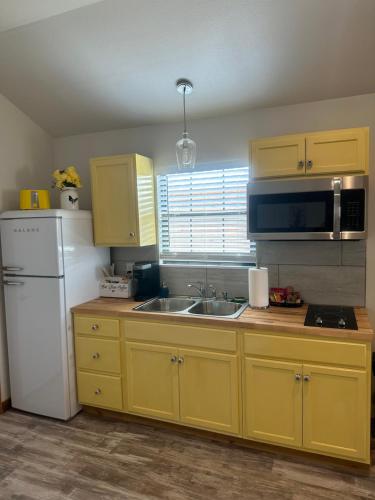 HyeYellow Rose Cabin的厨房配有黄色橱柜和白色冰箱