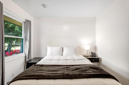 Ocean ParkCute as a Clam Cottage Room 5的白色的卧室设有床和窗户