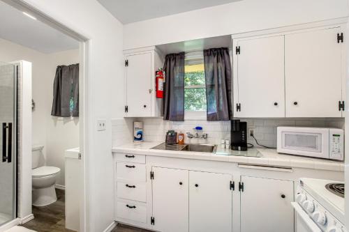 Ocean ParkCute as a Clam Cottage Room 5的白色的厨房配有白色的橱柜和微波炉