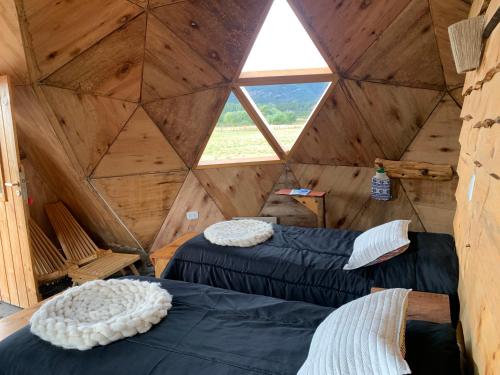 特来凡林Nomade Patagonia Glamping & Domos的木间设有两张床,设有窗户