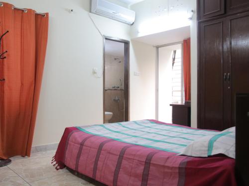 达卡Golpata Bed & Breakfast的一间卧室配有带条纹毯子的床