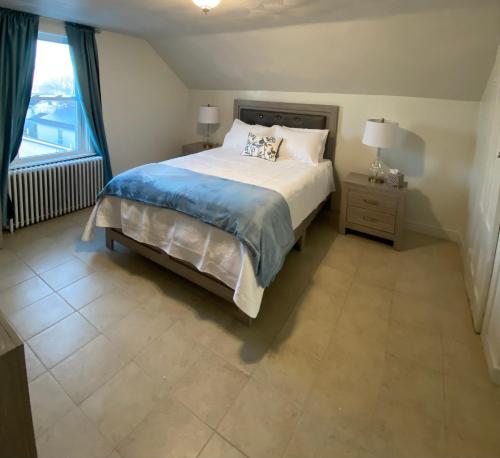 格洛斯特Spacious 2nd floor split level with scenic views of Gloucester的一间卧室设有一张大床和一个窗户。