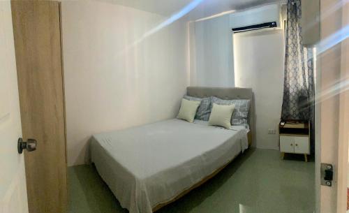 巴科洛德2 Bedroom townhouse in Bacolod City的一间小卧室,配有床和窗户