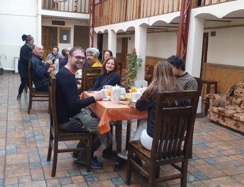 波托西Los Faroles Hostal的一群人坐在桌子旁