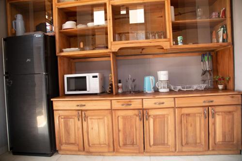布琼布拉Ruhuka House的厨房配有木制橱柜和冰箱。