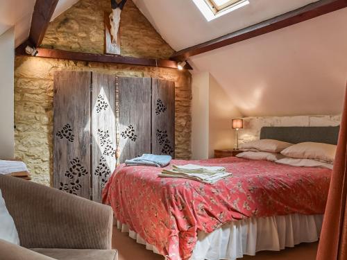 RamsdenThe Barn的一间卧室配有一张红色的床和木墙