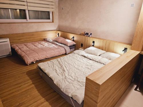 首尔Close to Gangnam, COEX & Luxury Apartment near Lotte world的铺有木地板的客房内的两张床