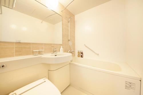 札幌札幌站前里士满酒店的浴室配有盥洗盆、卫生间和浴缸。