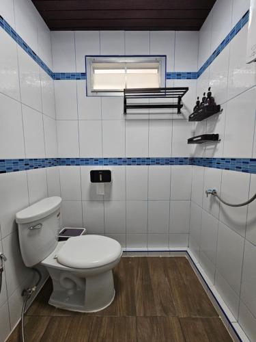 Ban Komo Sip PaetAnda Betong Homestay的一间带白色卫生间的浴室和窗户。