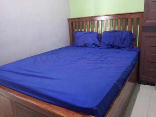 LaweanOYO 93012 Griya Kencana Asri Syariah的一张带蓝色床单和蓝色枕头的床