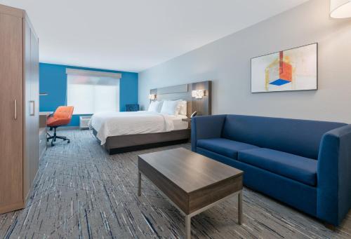 沙科皮沙科皮快捷假日酒店及套房的酒店客房,配有床和蓝色的沙发
