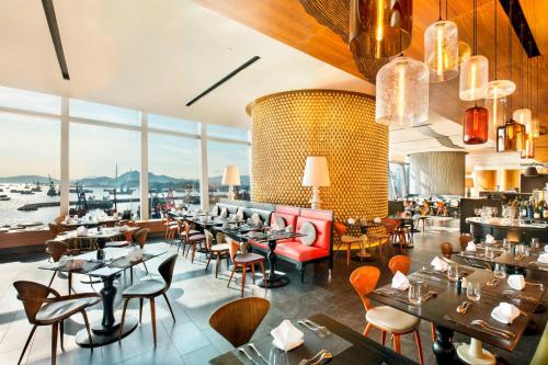 香港香港W酒店的餐厅设有桌椅和大窗户。