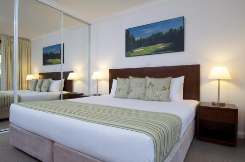 萨拉曼德湾Club Wyndham Port Stephens的卧室配有一张白色大床和两盏灯。