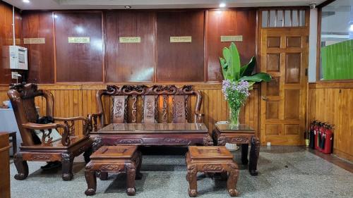 Dồng XoàiKhách Sạn Phương Lâm的木凳,带两把椅子和花瓶