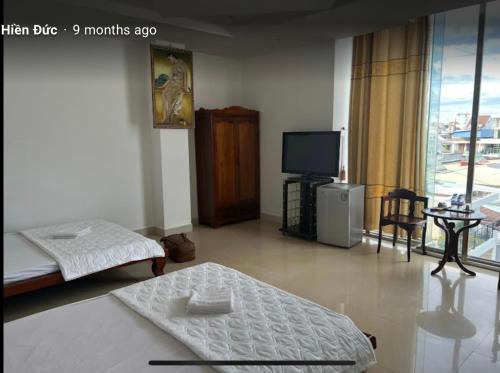 Dồng XoàiKhách Sạn Phương Lâm的客房设有两张床和一台平面电视。