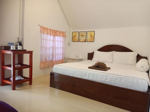 瓜隆岛班南简易别墅和餐厅宾馆的一间卧室,配有一张床,上面有帽子
