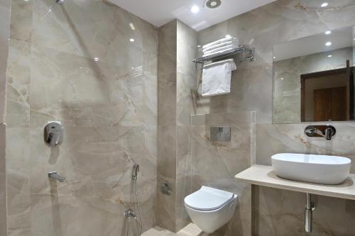 新德里The Saina International - New Delhi - Paharganj的浴室配有卫生间、盥洗盆和淋浴。