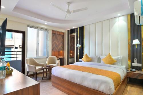 新德里The Saina International - New Delhi - Paharganj的酒店客房设有一张大床和一张书桌。