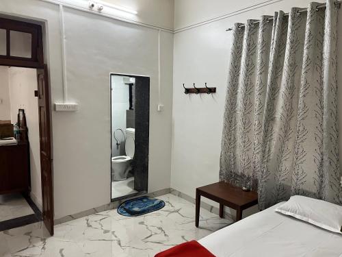 浦那Hotel Laxminarayan Niwas的一间卧室配有一张床,浴室设有卫生间