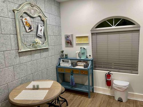 阿赫瓦尼Quail Suite HOT TUB BBQ Sleeps 2的一间设有桌子、镜子和桌子的房间