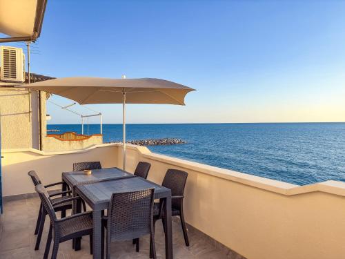 博尼法蒂Appartamento Fronte Spiaggia con Terrazza Vista Mare的阳台配有桌椅