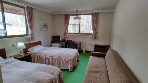 小谷村松之木亭酒店的酒店客房,设有两张床和一张沙发