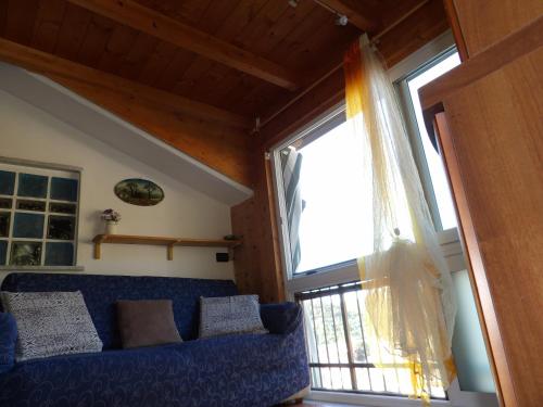 卡萨尔扎利古雷Gala的客厅设有蓝色的沙发和窗户。