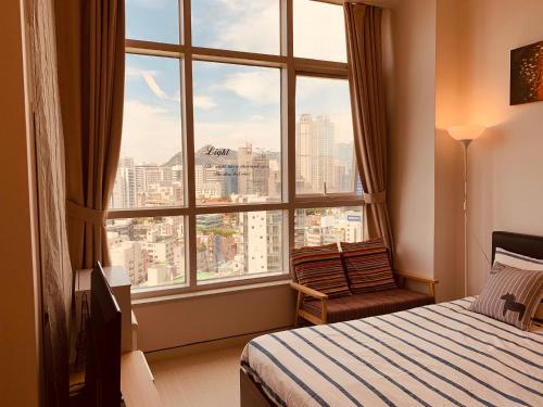 首尔旅行者之家酒店的卧室设有大窗户,享有城市美景