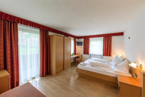 圣维吉利奥格兰佩里酒店的酒店客房设有一张大床和一张书桌。