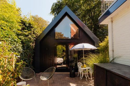 卑尔根Studio Verver的一间设有黑色屋顶和庭院的小房子